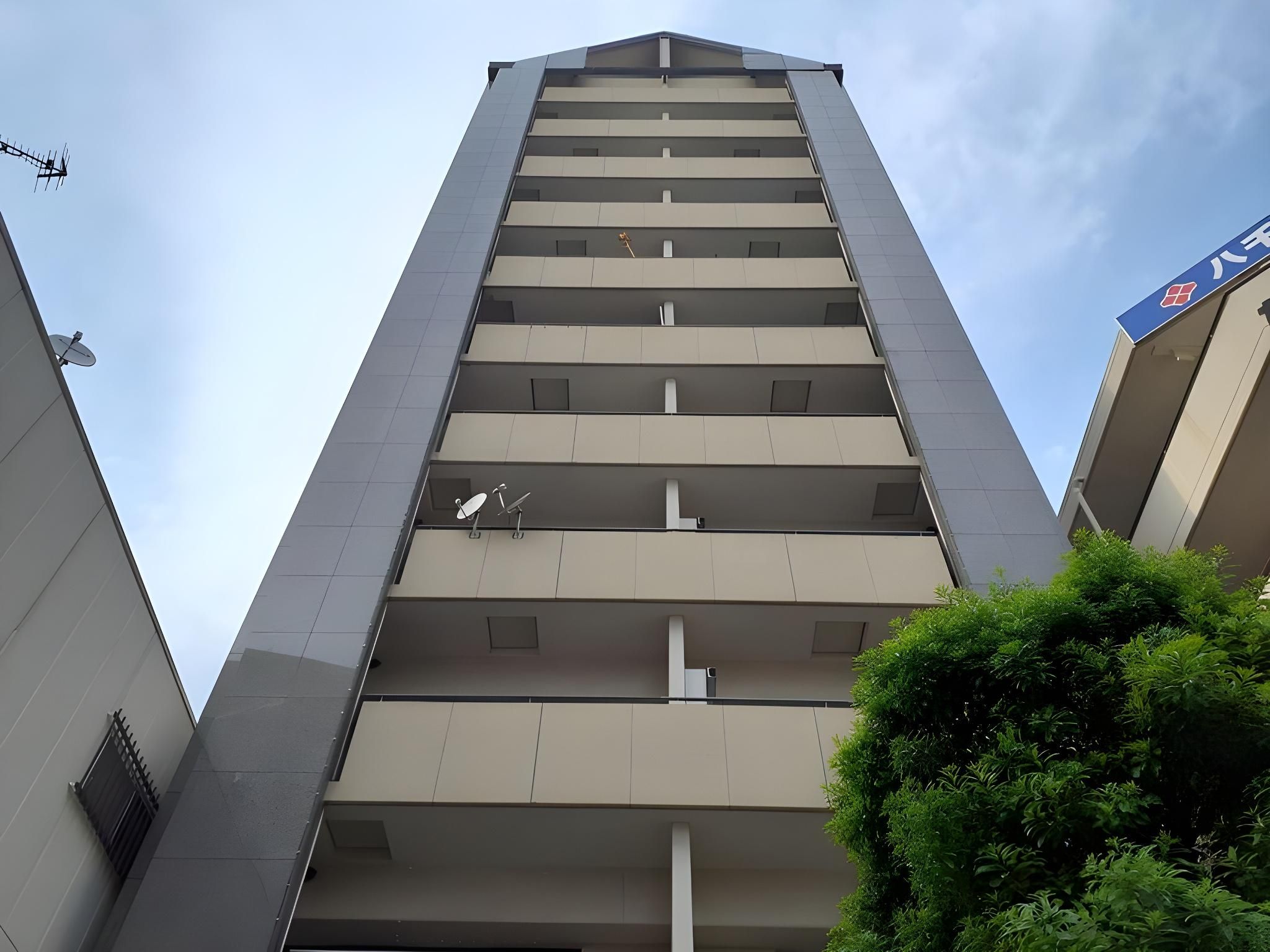 Um edifício alto com várias varandas, uma antena parabólica e uma placa indicando uso comercial.