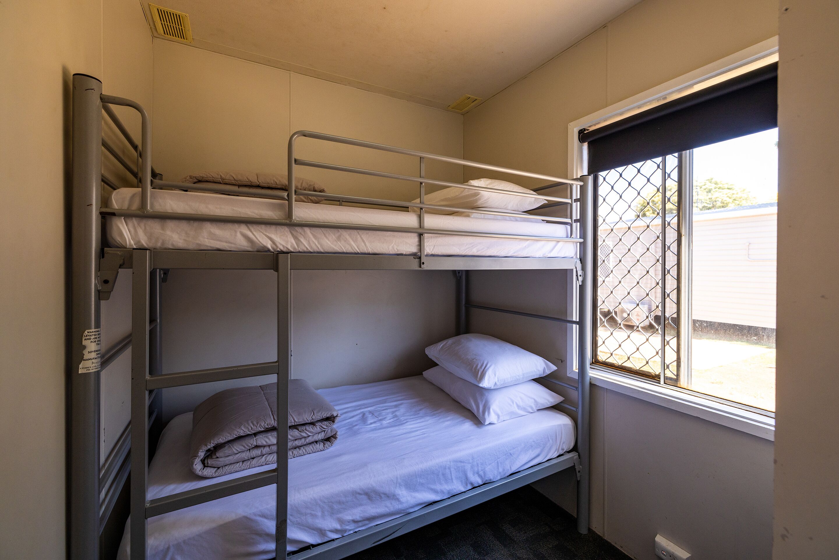 Dormitorio con literas, una ventana y una puerta.