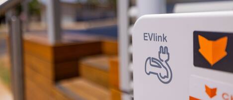 Una señal con el logotipo de EVLink y un símbolo de enchufe, que indica la disponibilidad de carga para vehículos eléctricos.