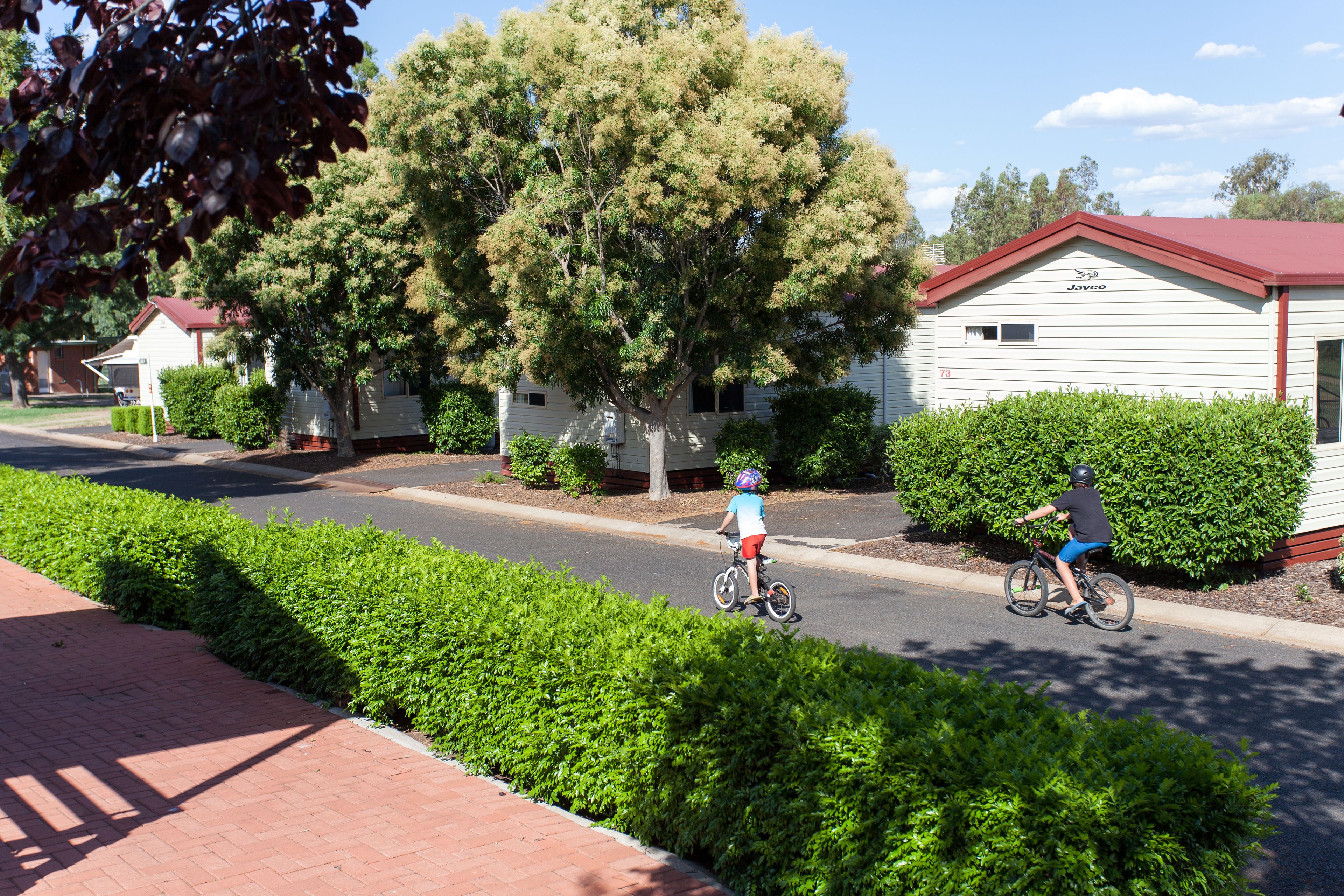 A residential street with two houses, one with a red roof and another with a white roof.