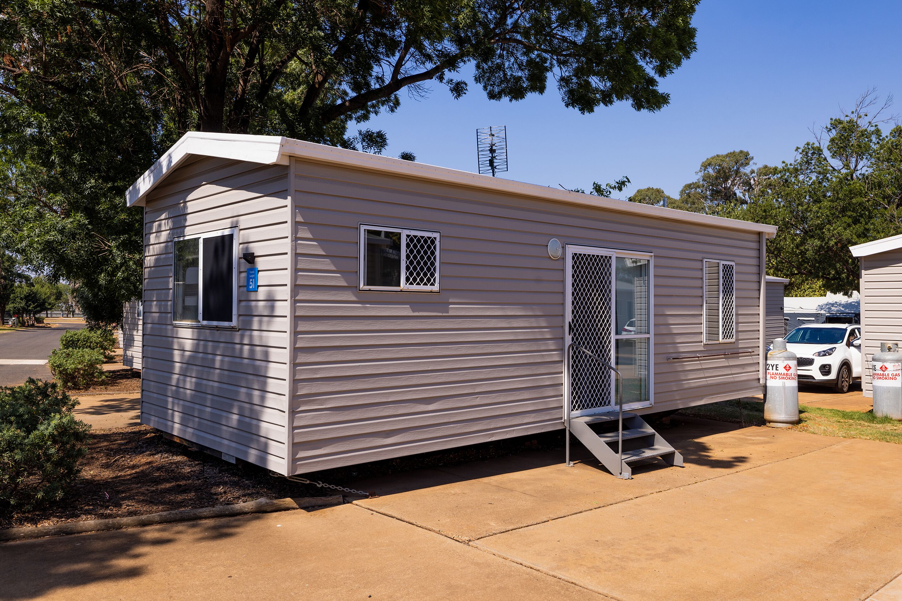 A single-story mobile home with a front door, a small porch, and a side entrance.