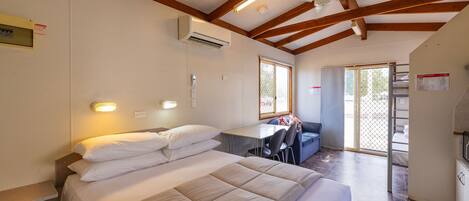 A bedroom with a bed, a desk, and a chair.