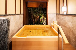 Tinaja de madera con vista a un jardín de bambú.