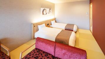 Quarto de hotel com duas camas, um sofá vermelho e uma obra de arte pendurada na parede.