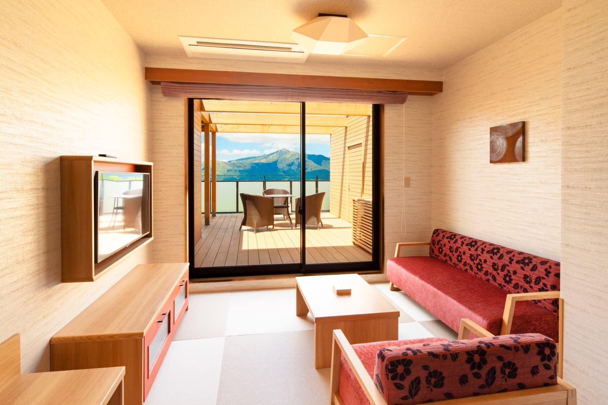 A modern interior with a sofa, chairs, a table, and a television.
