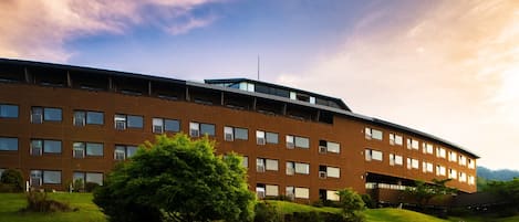 A multi-story building with a flat roof and a central antenna.