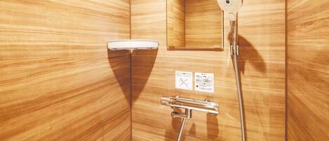 A wooden bathroom with a shower, a mirror, and a towel rack.
