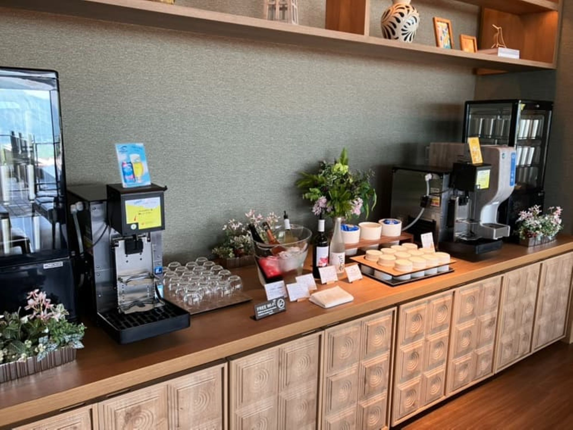 A self-service coffee station with multiple coffee machines, a variety of drink options, and a selection of condiments and utensils.