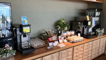 A self-service coffee station with multiple coffee machines, a variety of drink options, and a selection of condiments and utensils.