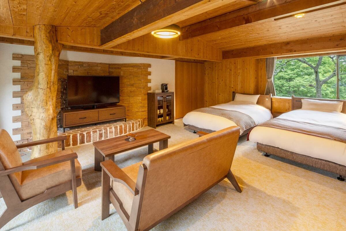 Ein Holzinterieur mit Fernseher, einer Couch und zwei Betten.