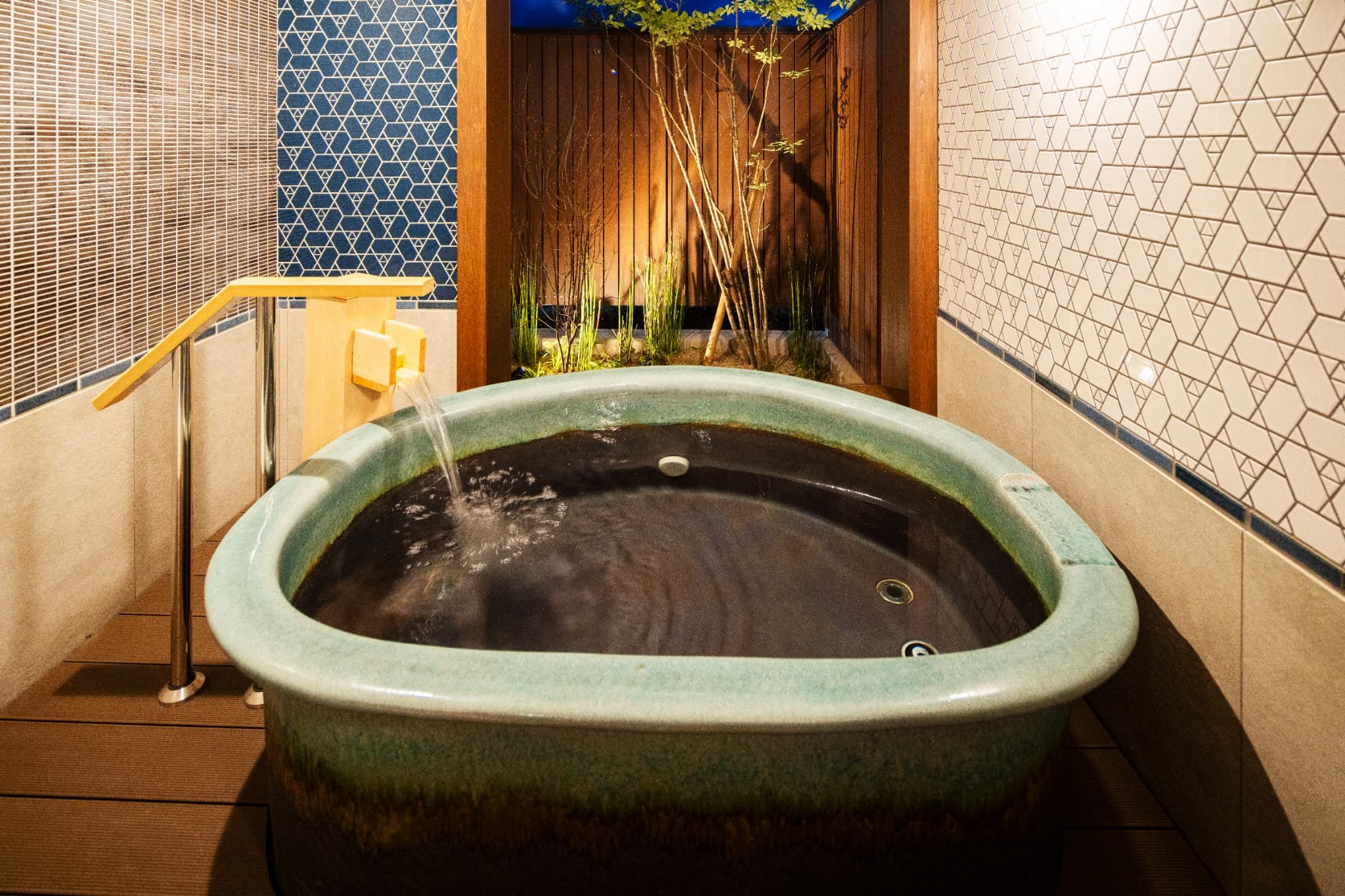 A spa area with a hot tub, wooden flooring, and tiled walls.