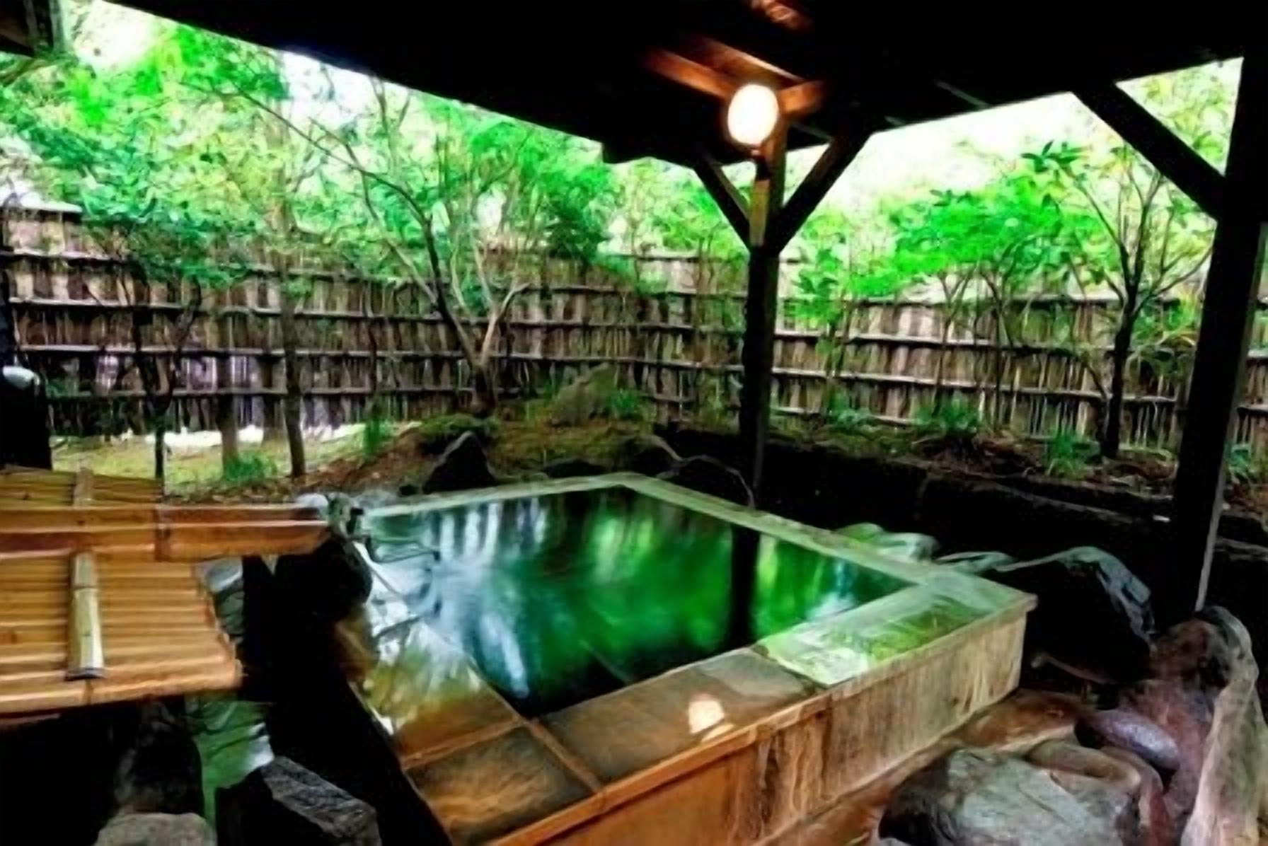 Un área de aguas termales con bancos de madera y una valla de madera.