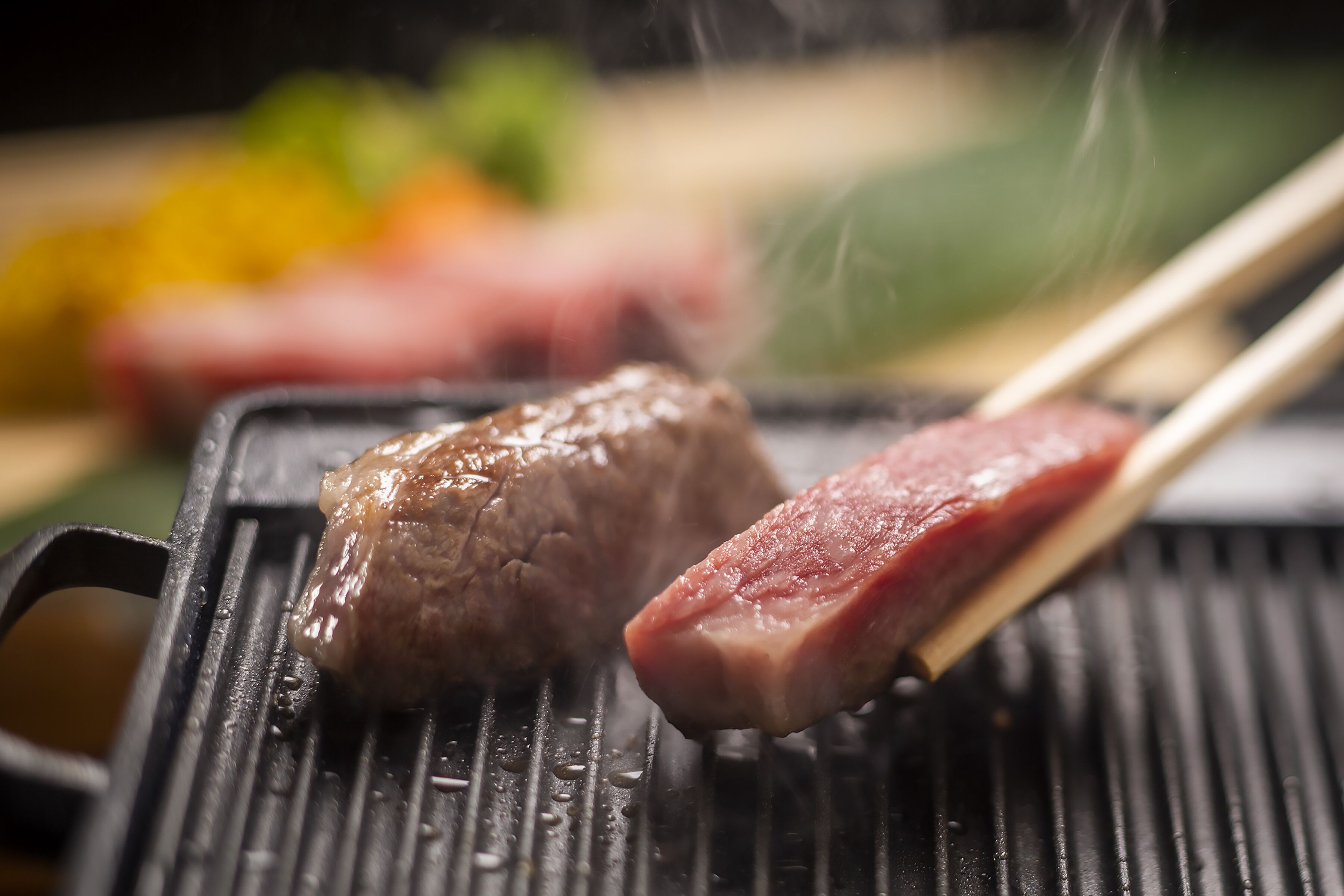 Grilli, jossa on kaksi grillattavaa lihapalaa.