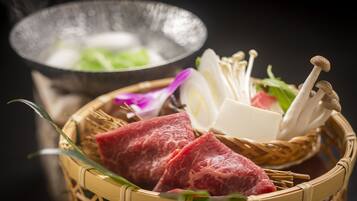 A basket with raw meat, mushrooms, and vegetables, possibly for a meal.