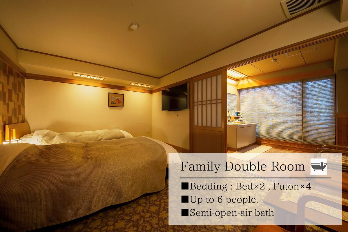 Ein Familienzimmer mit Bett, Futon und halboffener Badeanlage.