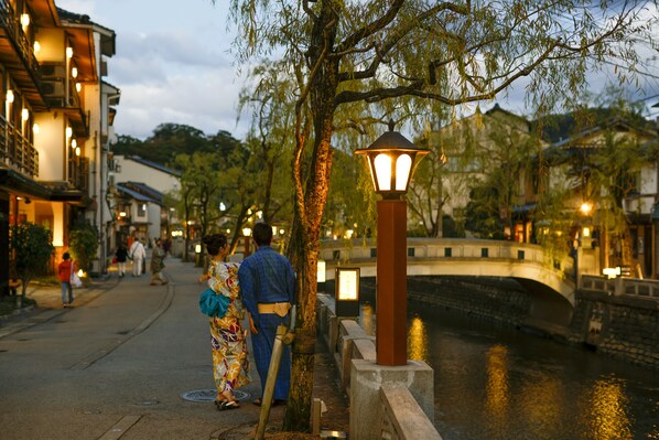 Escena callejera tradicional con edificios, un puente y un río.