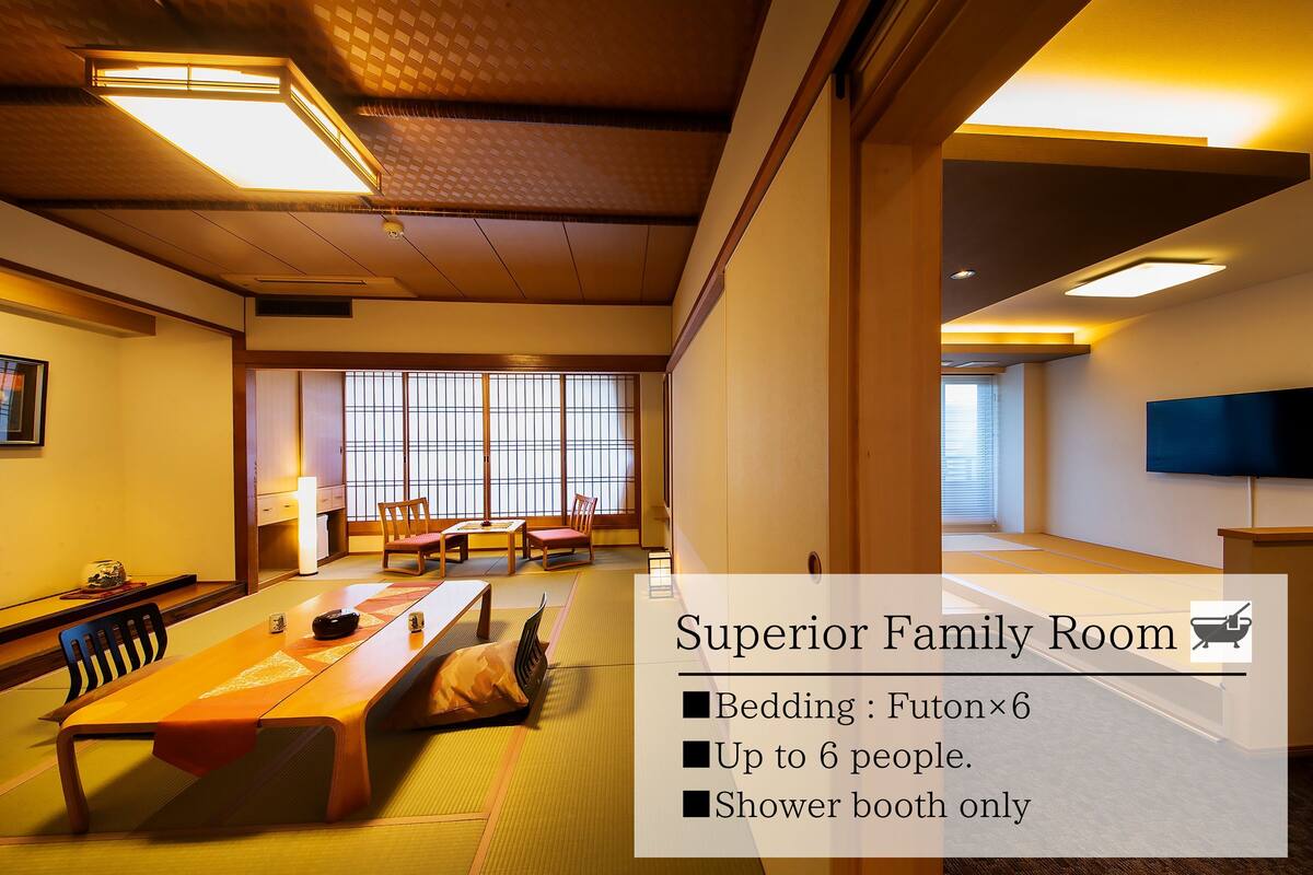 Eine Superior-Familienzimmer mit Futon, Holztisch, Tatami-Matten, Fernseher und Duschkabine.