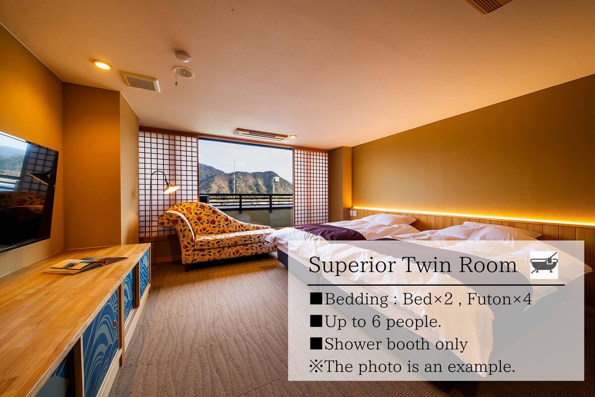 Ein komfortables Doppelzimmer mit Bett, Futon, Fernseher und Bergblick.