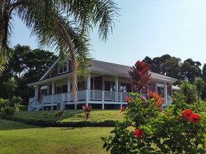 A two-story house with a covered porch and a lawn.