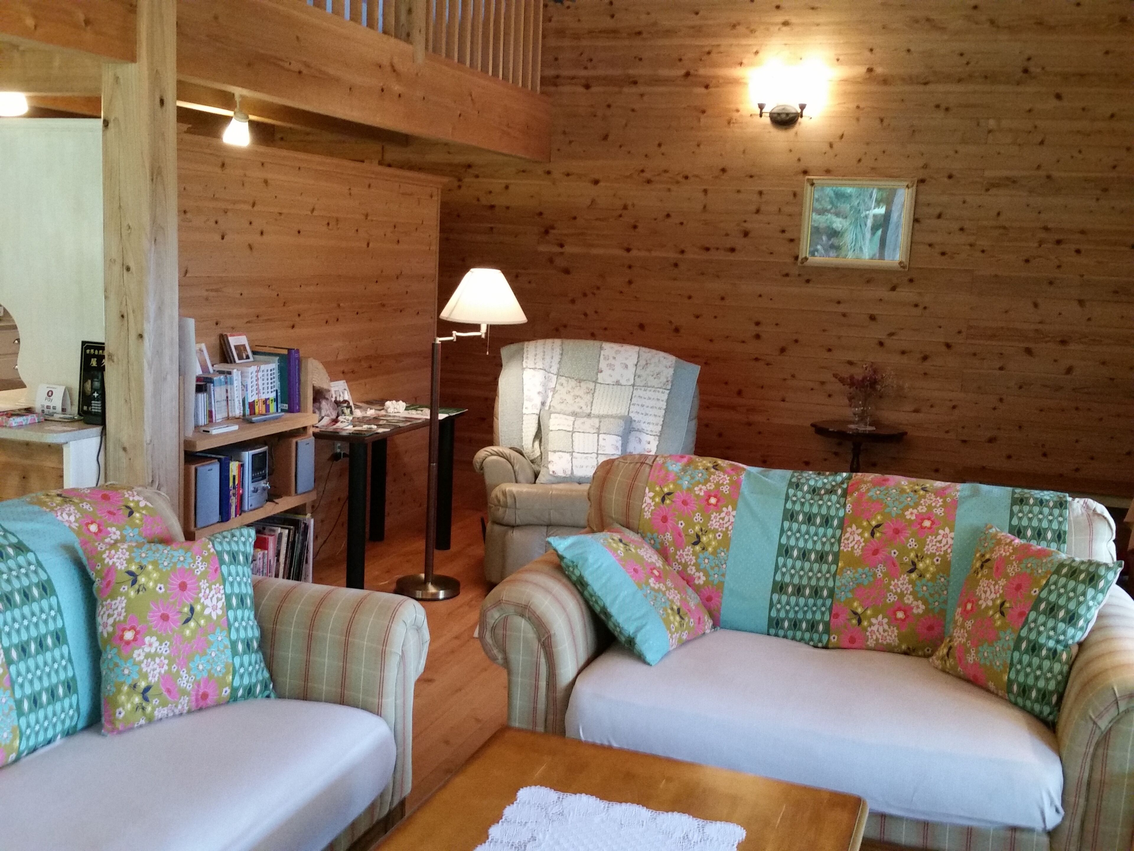 Ein gemütliches Cabin-Interieur mit zwei Sofas, einem Tisch, einer Lampe und einem Bücherregal.