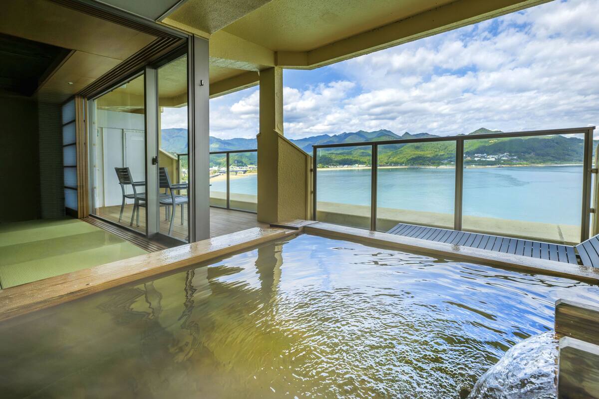 Ein Balkon mit Blick auf Strand und Berge.