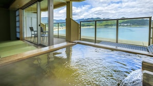 A balcony with a view of a beach and mountains.