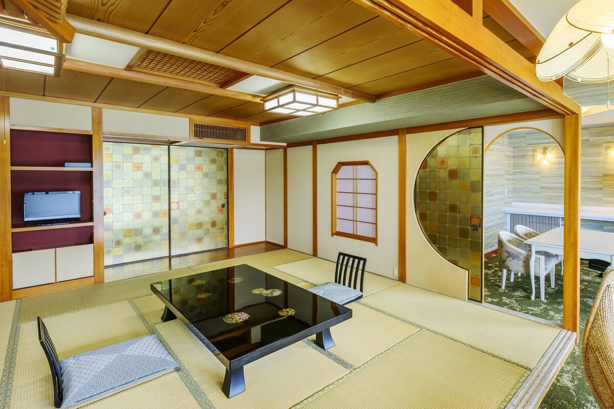 Ein traditioneller japanischer Raum mit Tatami-Böden, einem niedrigen Tisch und Schiebetüren.