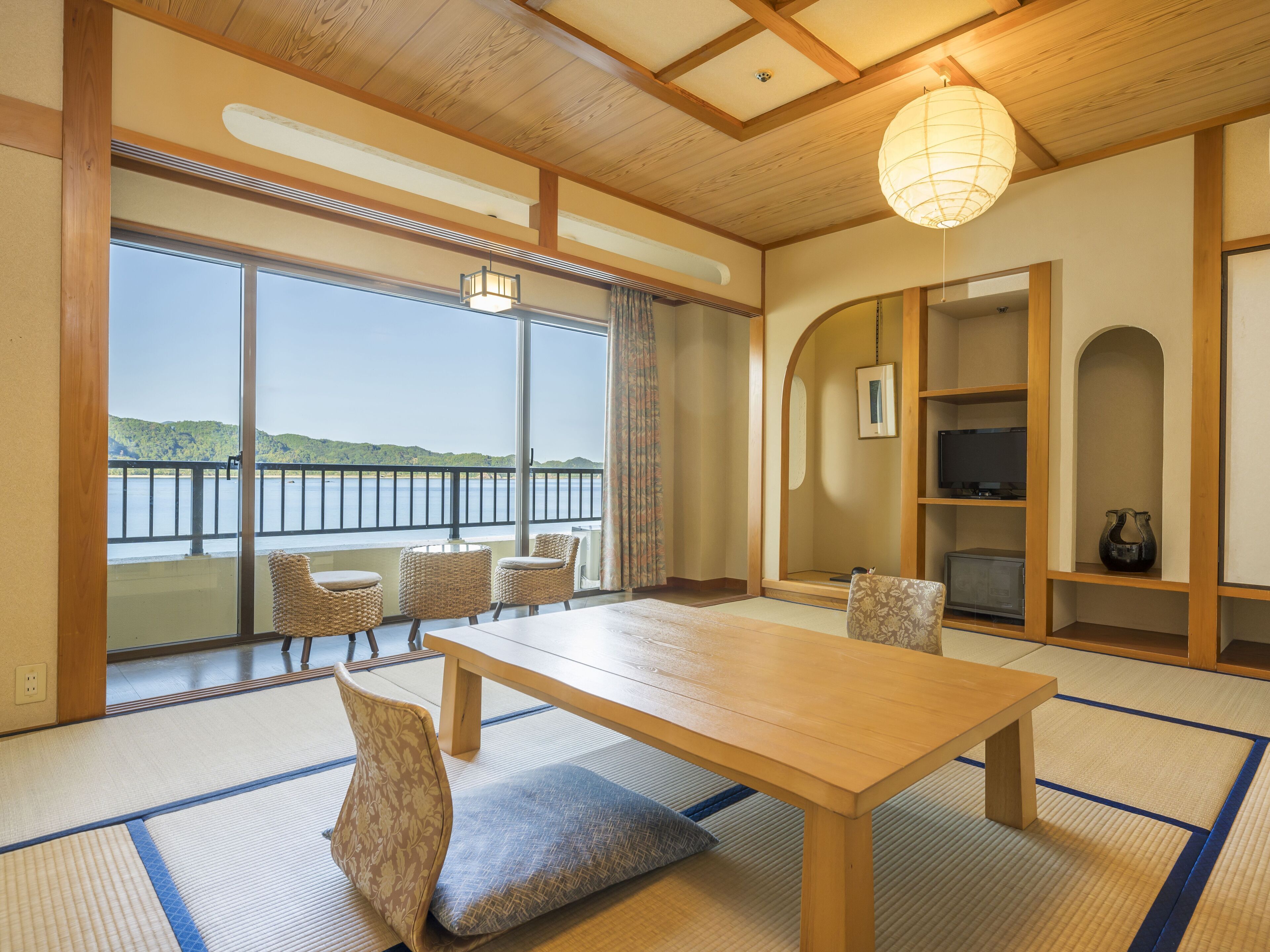 A traditional Japanese room with tatami flooring, a wooden table, and chairs.