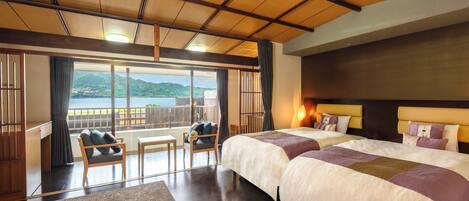 Quarto de hotel com duas camas, uma varanda e vista para o mar, e teto de madeira.