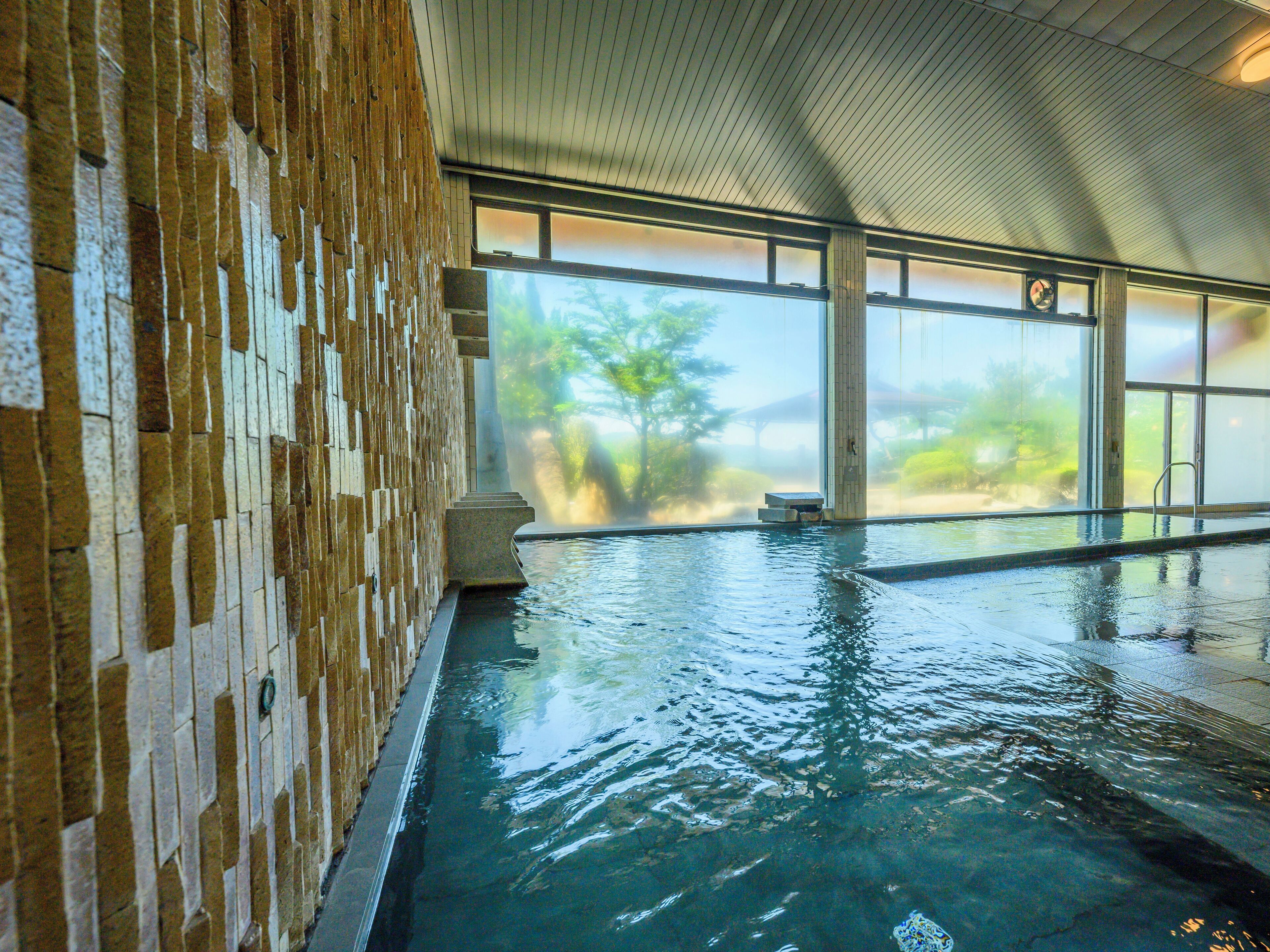 Ein Hallenbad mit einer Backsteinwand und großen Fenstern.