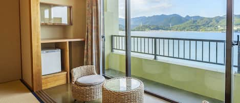 A balcony with wicker furniture and a view of mountains.