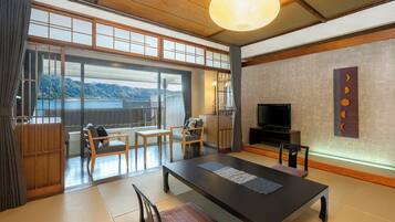 A traditional Japanese-style room with tatami flooring, a low table, and a television.