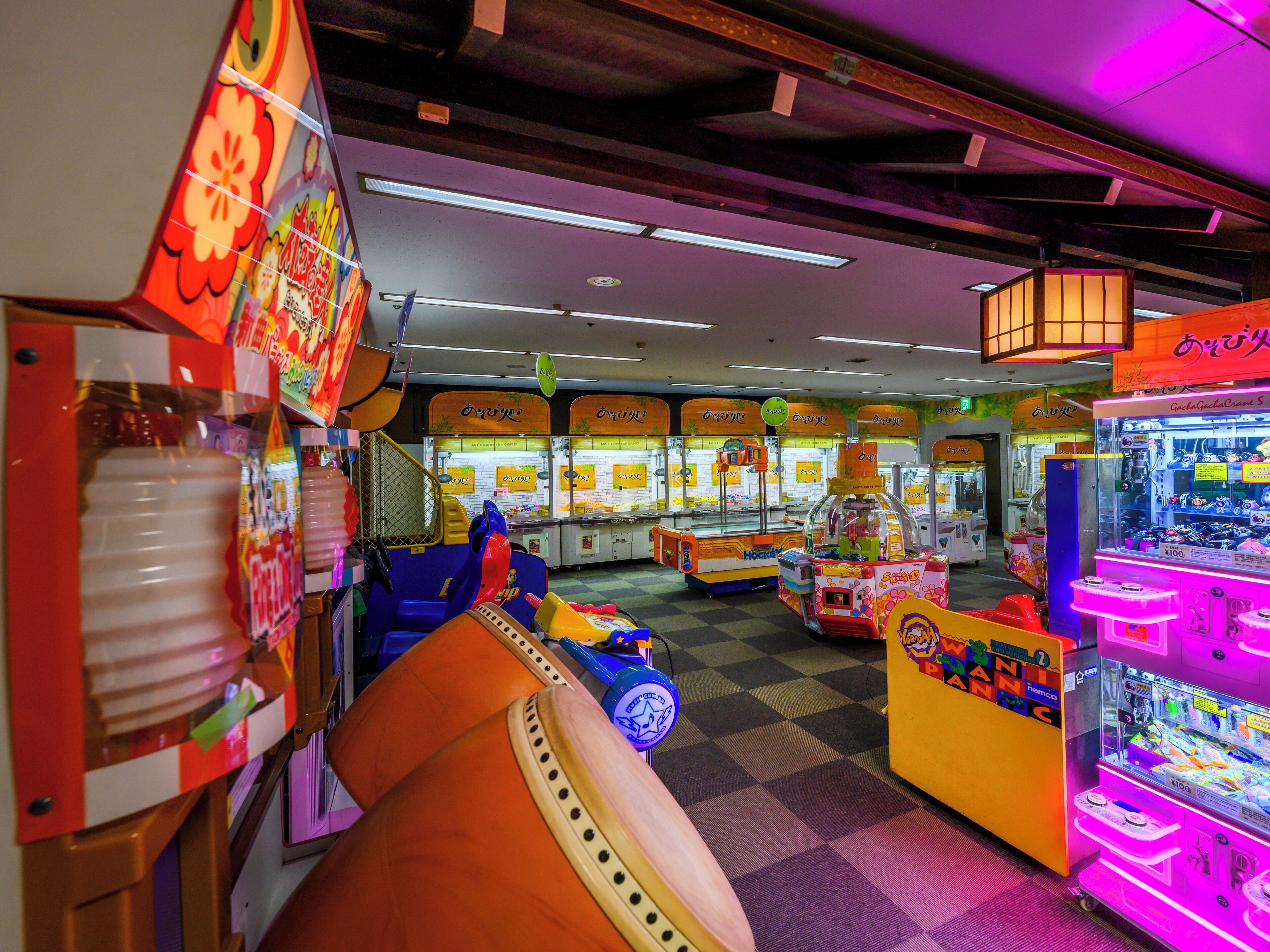 An arcade with various gaming machines and a checkered floor.