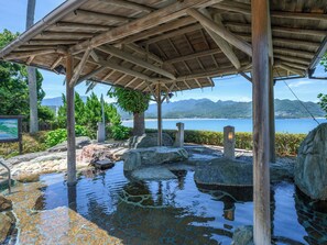 A wooden pavilion with a view of a calm lake and mountains in the distance. - KAMENOI HOTEL NACHI KATSUURA KUMANO KODO (Nachikatsuura)