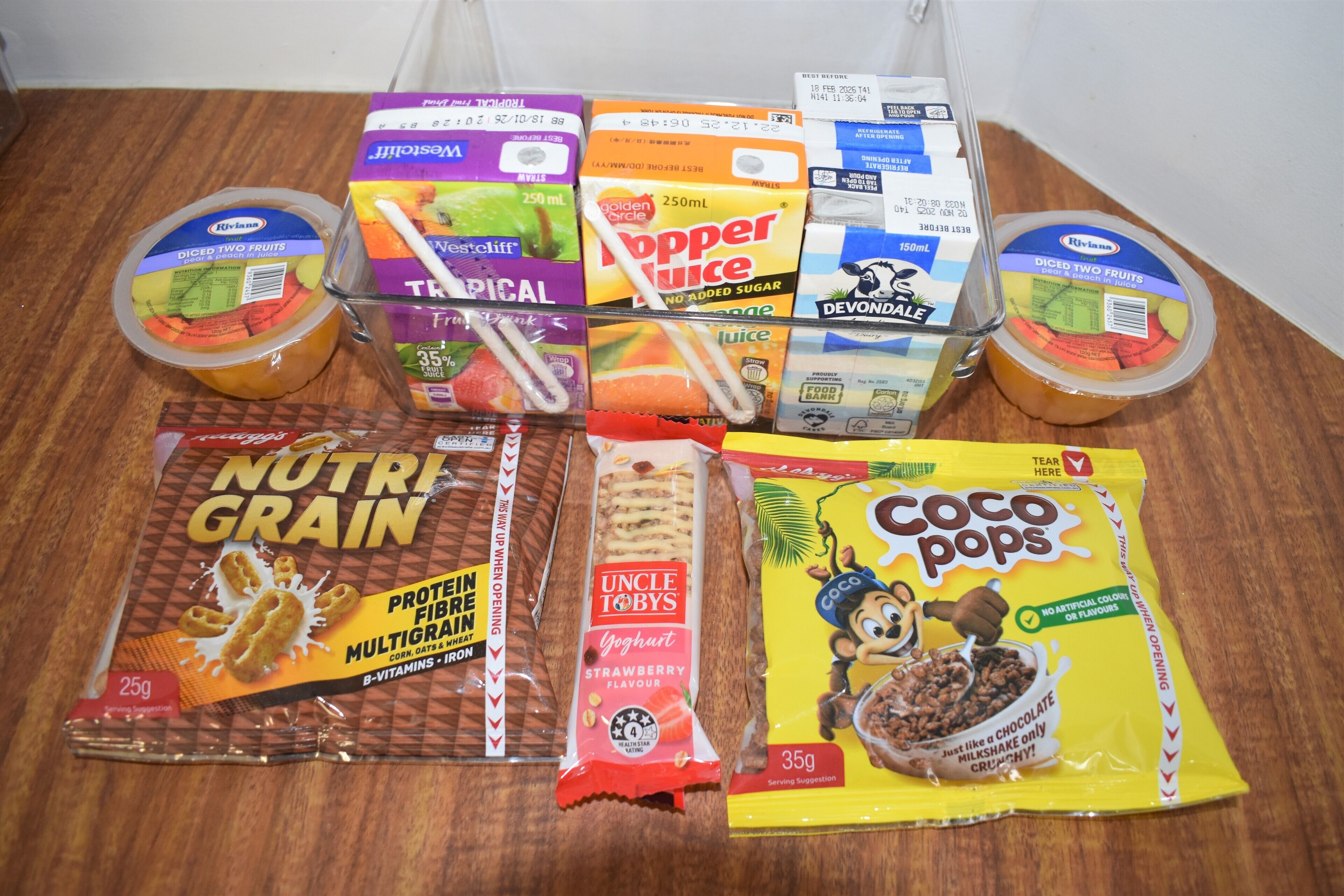 A variety of packaged food items including cereal, yogurt, and fruit juice.