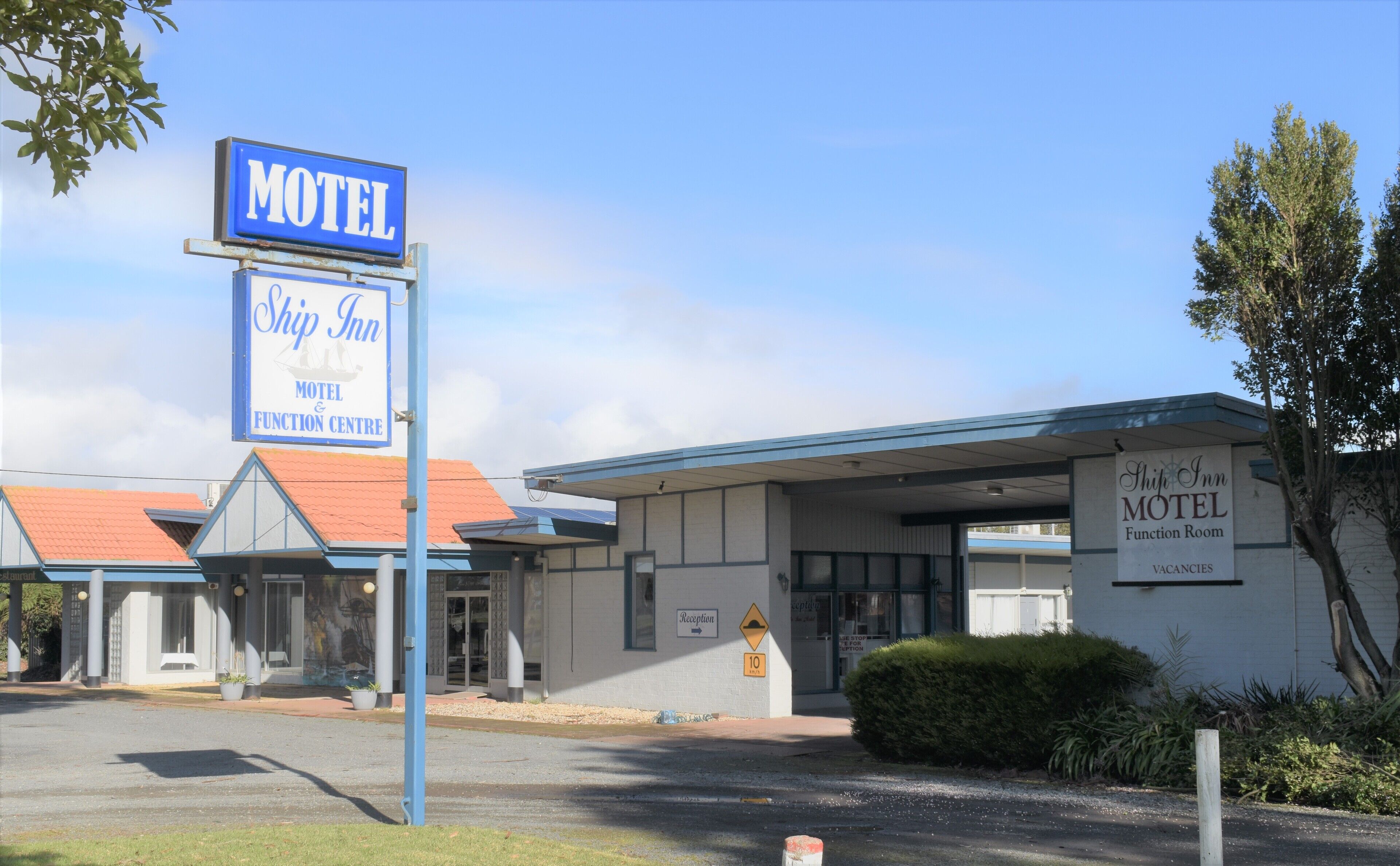 A motel with a sign indicating a function room and reception.