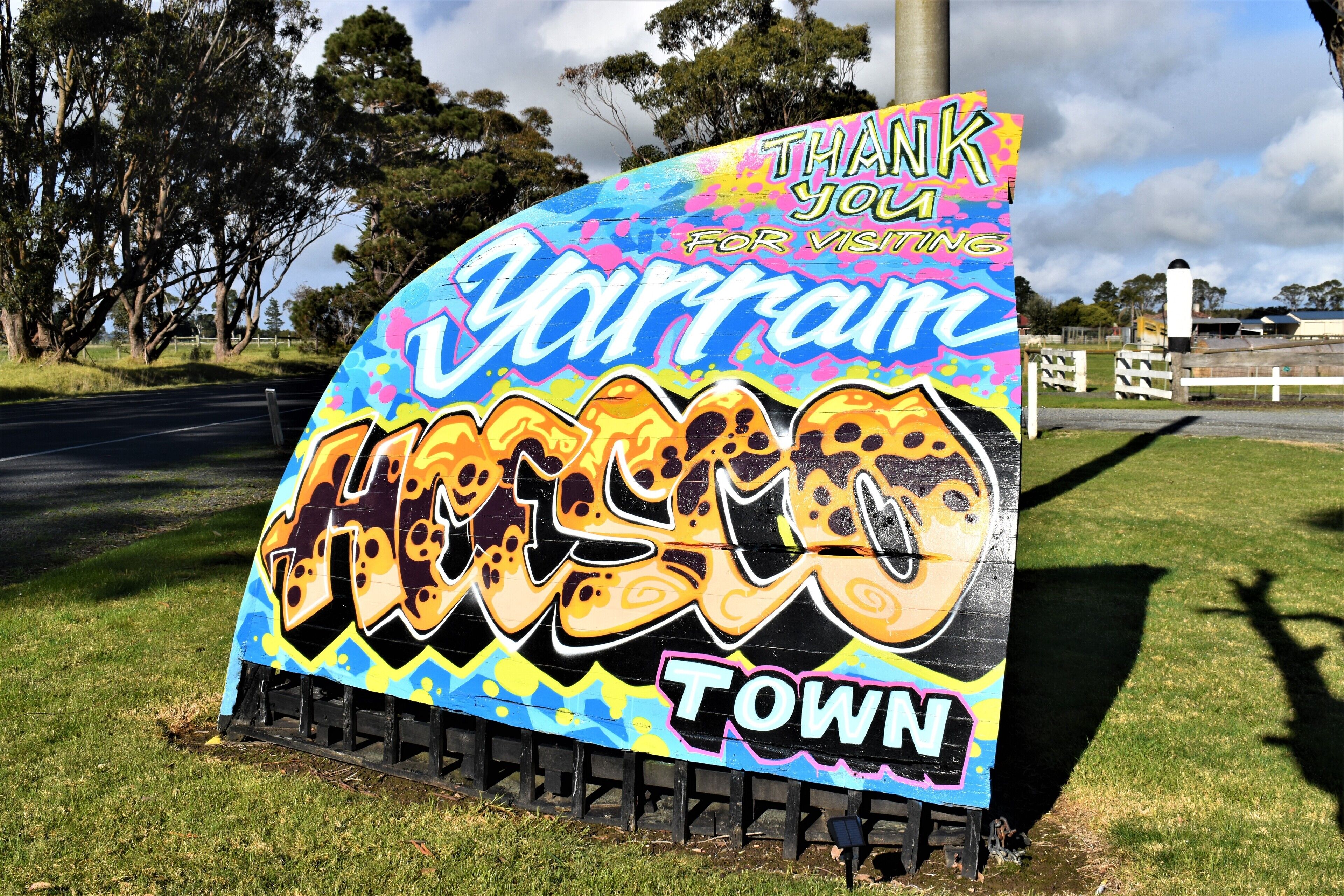 A colorful sign with the text "Thank you for visiting Warrnambool Town" and a graphic of a face.