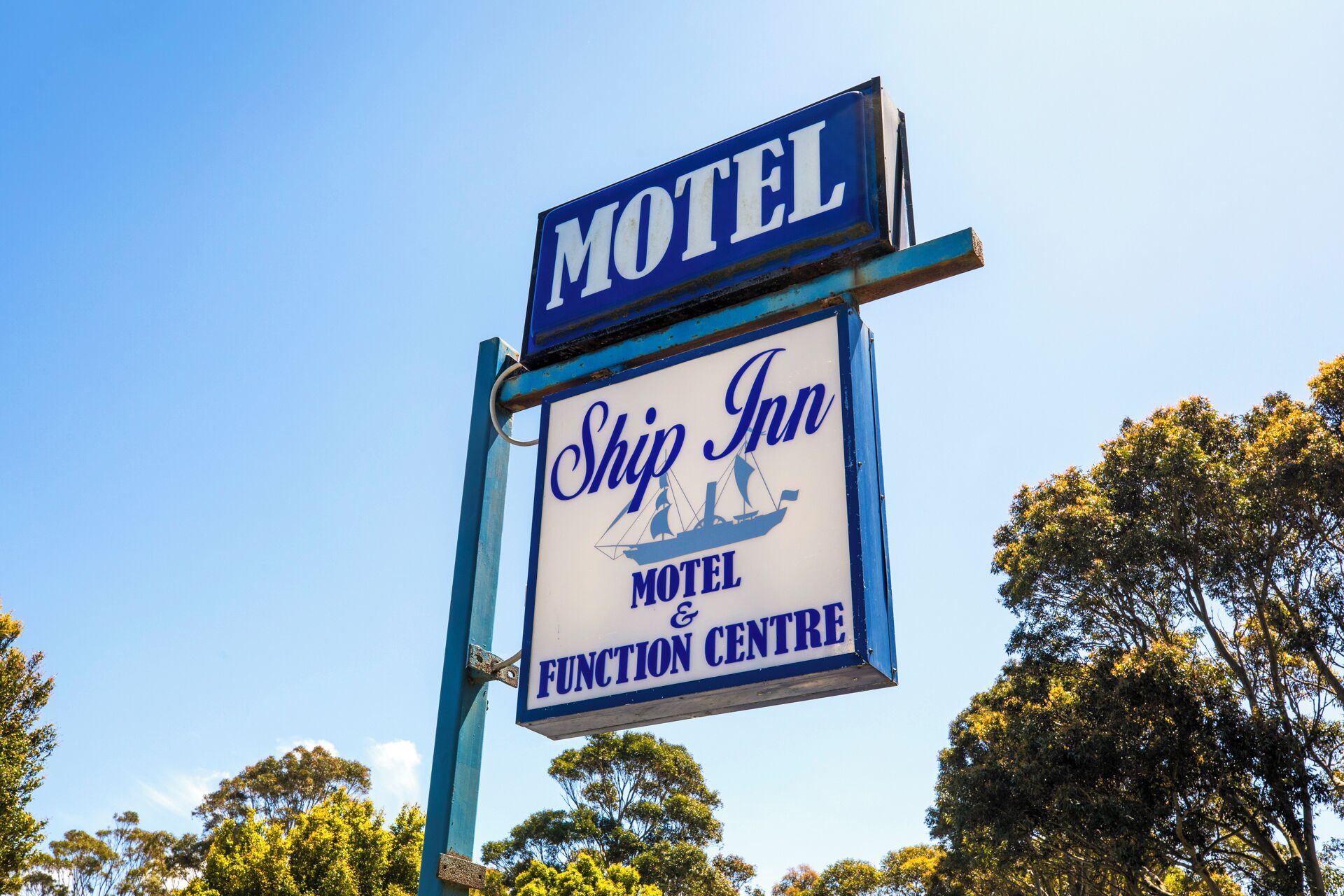 A motel sign with 'Motel' and 'Ship Inn Motel & Function Centre' written on it.