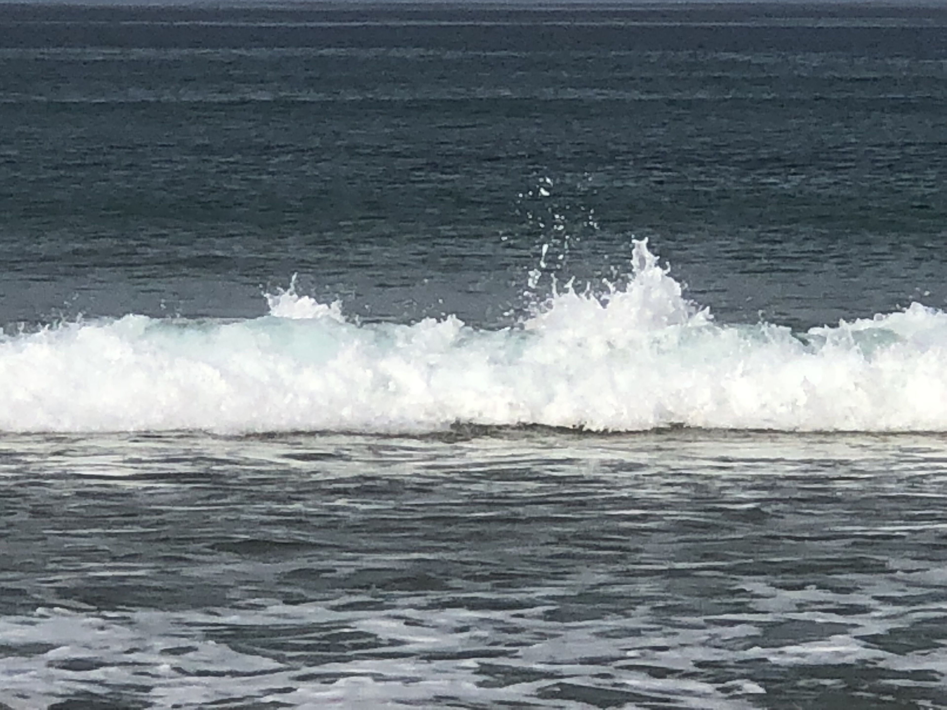 Vista del océano con olas rompiendo en la orilla.