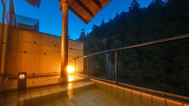 A wooden deck with a glass railing overlooking a forested area at night. - Kyoto Miyama Ryori Ryokan Chinsenro (Nantan)