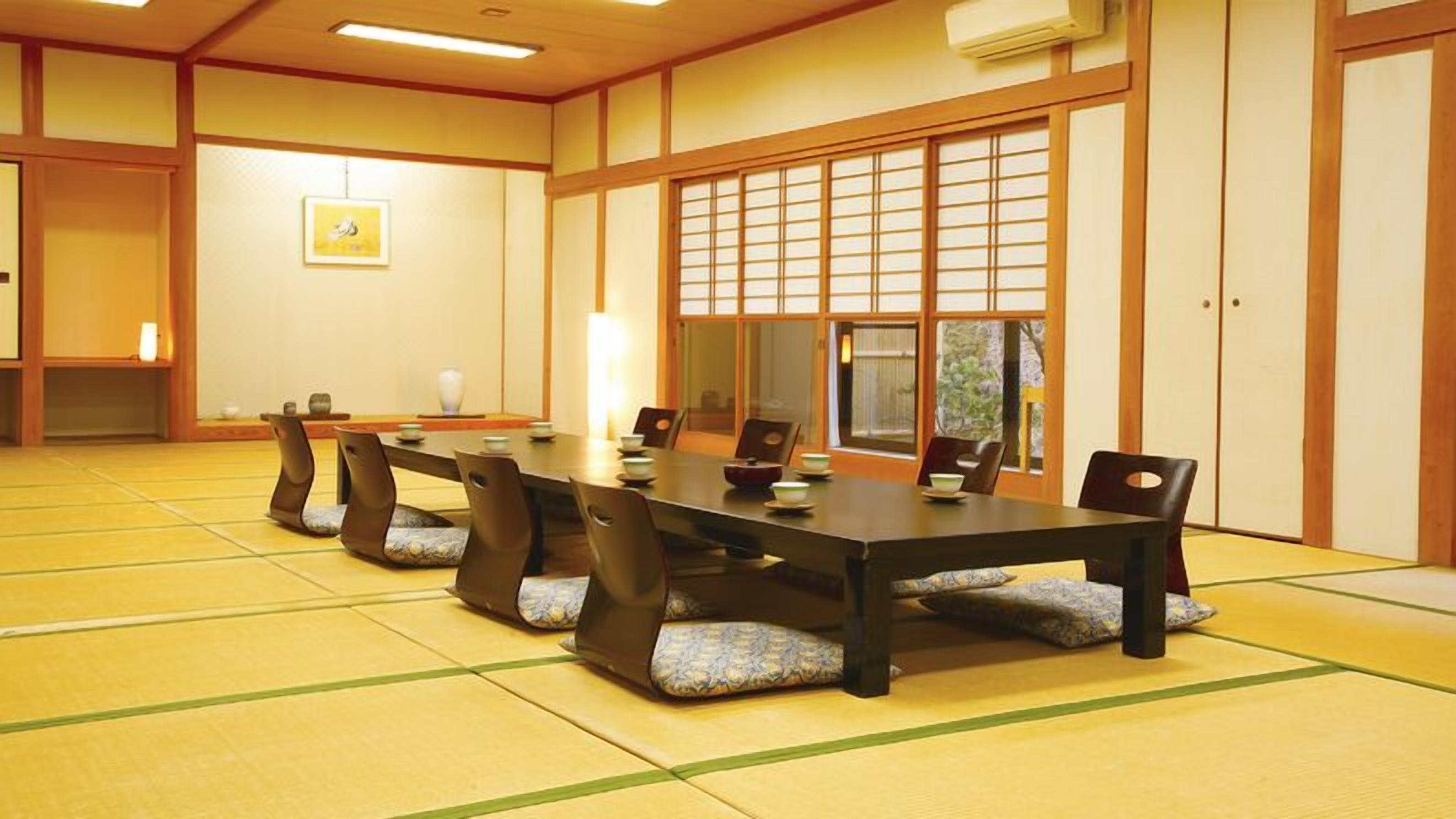 Een traditionele Japanse kamer met tatami vloerbedekking, een lage tafel en glijdende deuren.