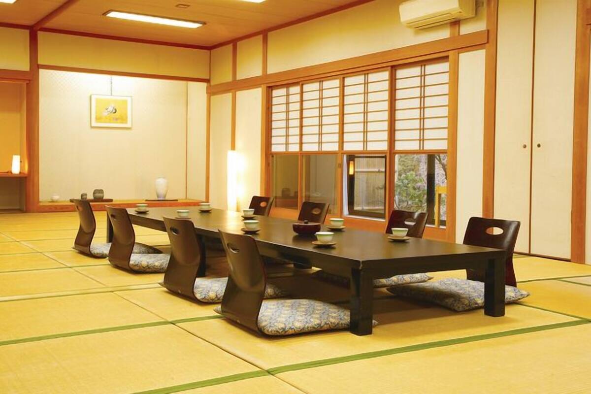 A traditional Japanese-style room with tatami flooring, a low table, and sliding doors.