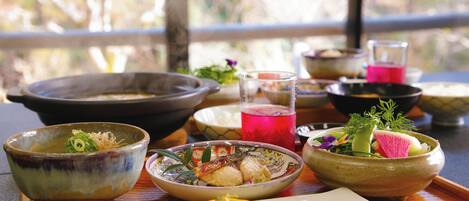 A variety of traditional Japanese dishes and drinks on a wooden table.