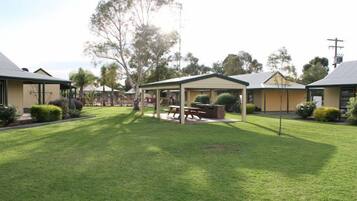 A courtyard with a covered seating area, a picnic table, and a small play area.