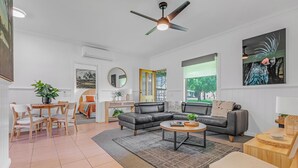 Ein modernes Wohnzimmer mit Sofa, Couchtisch und Essbereich.