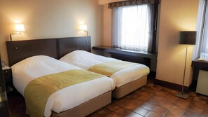 A hotel room with two beds, a desk, a lamp, and a window with curtains. - Hotel Urban Ikebukuro (Tokyo)