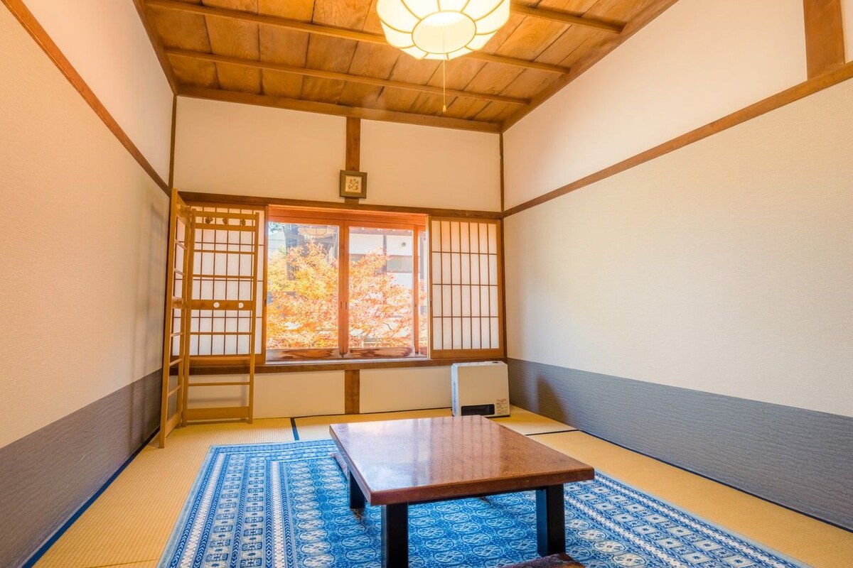 A traditional Japanese room with tatami flooring, a low table, and shoji screens.