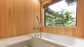 A modern bathroom with a wooden interior, a bathtub, a shower, and a window with a view of greenery. - Ekoin (Koya)