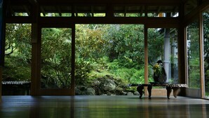 A traditional Japanese room with tatami flooring, a stone lantern, and a view of a lush garden through large sliding doors. - Ekoin (Koya)