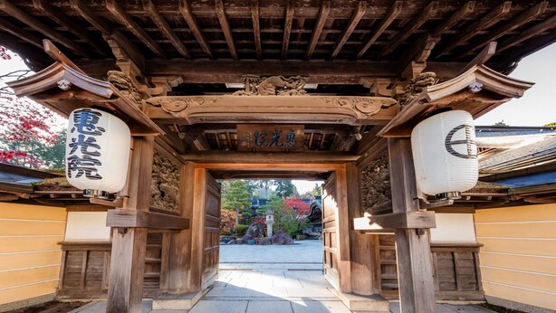 A traditional Japanese gate with intricate carvings and a wooden structure. - Ekoin (Koya)